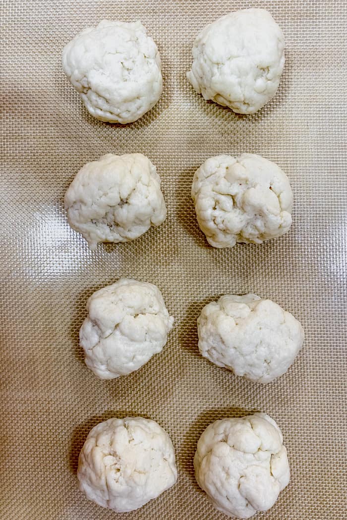 8 dough balls placed on a baking mat