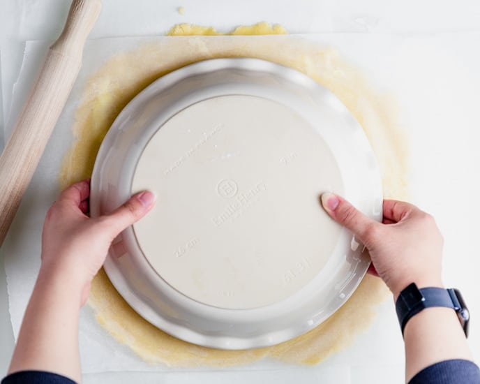 holding the pie dish plate on top of the pastry dough