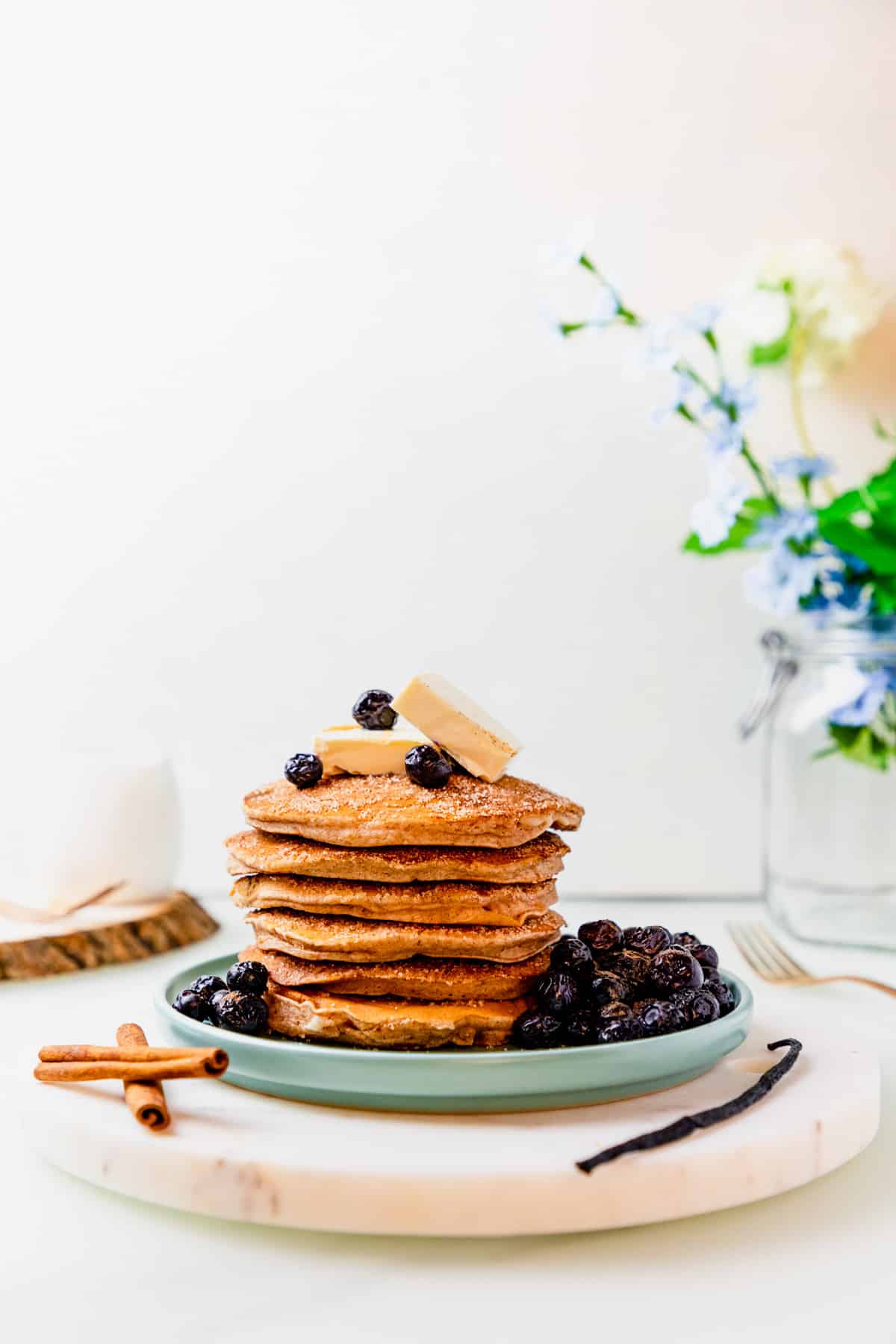 gluten free snickerdoodle pancakes stacked on top of each other on a blue plate.