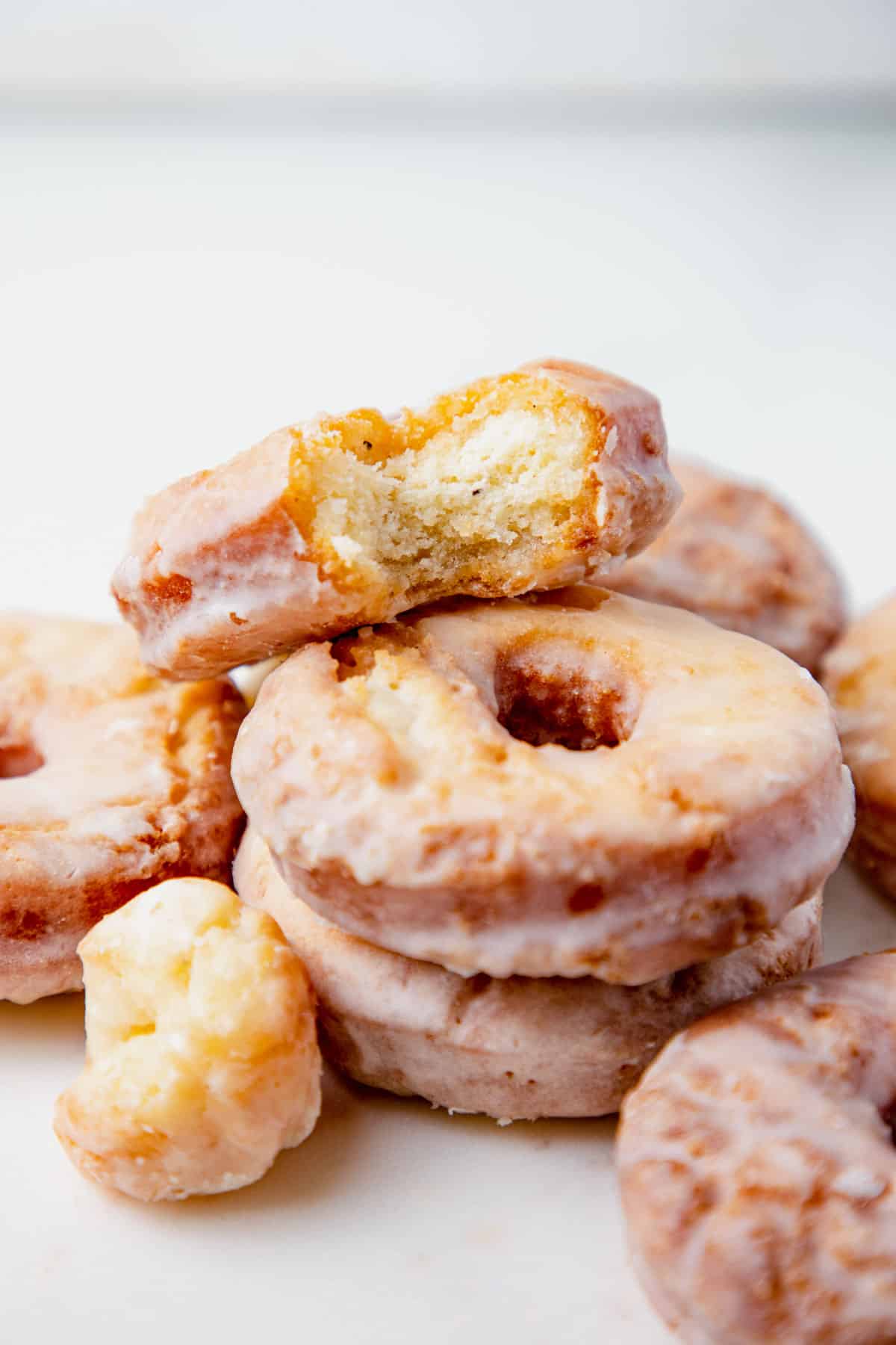 gluten free vanilla fried donuts placed on top of each other with one donut bitten. 