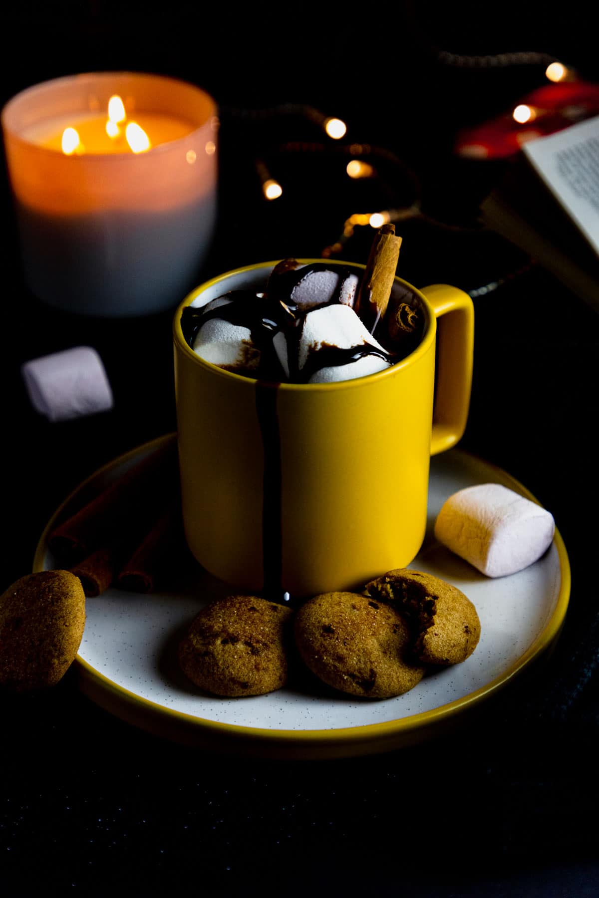 gluten free hot chocolate in a yellow mug topped with marshmallow and chocolate fudge.