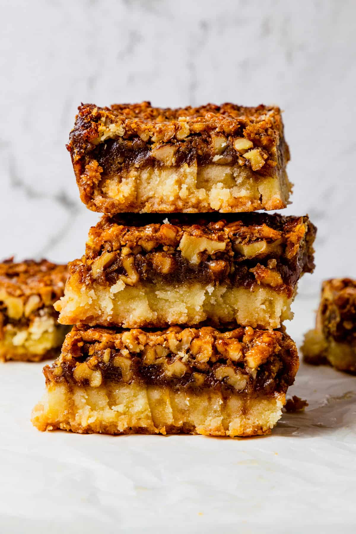 three gluten free pecan bars stacked on top of each other. 