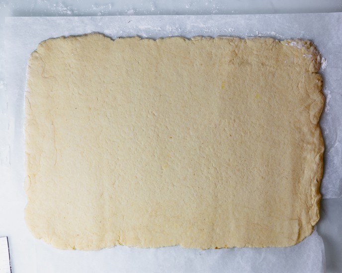 The gluten free cinnamon dough rolled into a rectangle on parchment paper.